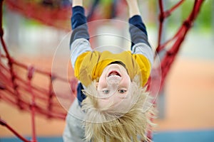ÃÂ¡ute perky preschooler boy having fun on outdoor playground. Spring/summer/autumn active sport leisure for kids. Outdoor photo