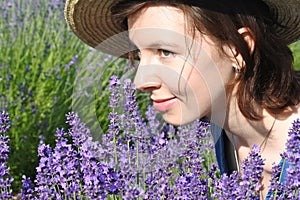 Ð¡ute smiling girl among lavender flowers. Closeup portrait.