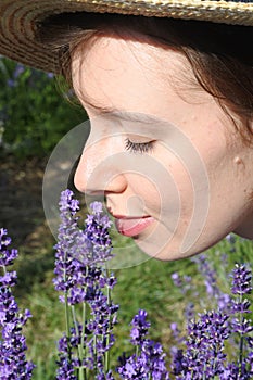 Ð¡ute smiling girl among lavender flowers. Closeup portrait.