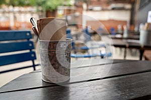 Utensil and napkin steel napkin placed on wooden picnic table in restaurant