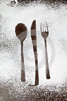 Utensil silhouette in sugar dust