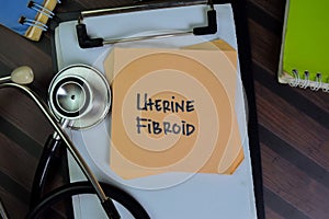 Uterine Fibroid write on sticky notes isolated on Wooden Table photo