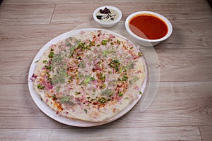 Uthappam or Uttapam is a type of dosa from southern India that is thicker, with tomato, onion, chilli packets