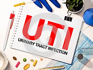 UTI Urinary Tract Infection written in notebook on white table