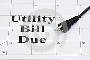 Utility bill due with electric cord plug on a calendar