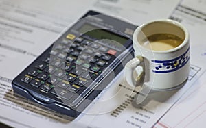 Utility bills, coffee and calculator