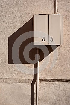 Utility Cabinet Mounted on Building Wall with Sharp Shadow