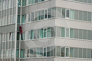 Utility climber while washing the windows of an office building