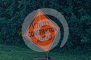 Utility Construction Ahead orange road warning sign