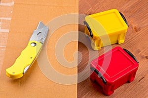 A utility knife on a brown box and two closed containers