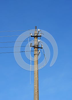 A utility pole, electrical post with broken power lines, damaged electrical cables after a storm, or hurricane as a cause of power