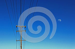 Utility pole and electricity wires and cables, blue sky, moon