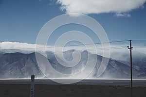 Utility pole and power lines running in front of mountains