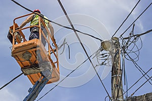 Utility pole worker installs new cables on an electric pole