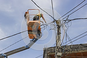 Utility pole worker replacing cables on an electric pole