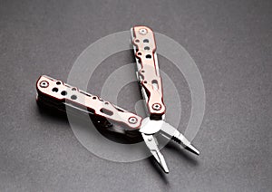 Utility tool knife with pliers and nozzles on a black background