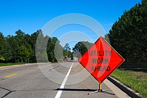 Utility Work Ahead sign with service vehicle on street