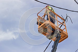 Utility worker fixes the power line