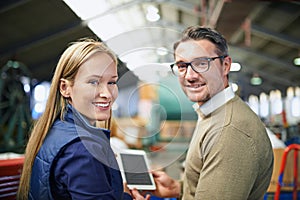 Utilizing the latest technology in the warehouse. Rearview portrait of a two managers using a digital tablet while