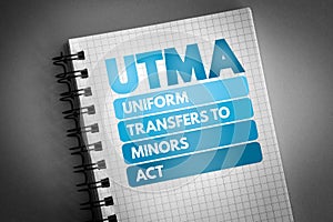 UTMA - Uniform Transfers to Minors Act acronym on notepad, law concept background