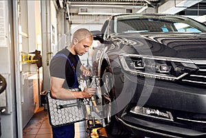 ÃÂuto mechanic sets the car for diagnostics and configuration collapse-convergence. Car Wheels alignment equipment on stand in a photo