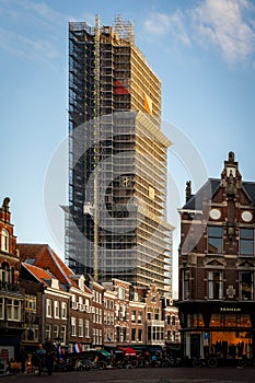 Cityscape view with incidental people of the famous Dom Tower of Utrecht undergoing renovation in Utrecht.