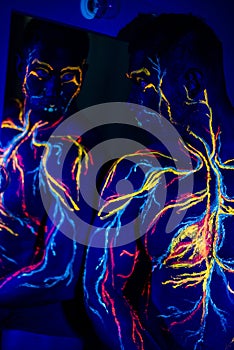 UV patterns body art of the circulatory system on a man`s body. On the chest of a muscular athlete, veins and arteries