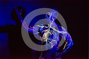 UV patterns body art of the circulatory system on a man`s body. On the chest of a muscular athlete, veins and arteries