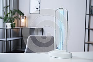 UV sterilizer lamp on table at home. Space for text