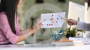 Ux developer and ui designer brainstorming about mobile app interface wireframe design on table.