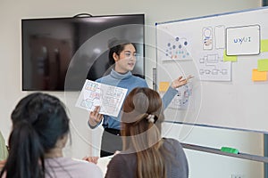 ux developer and ui designer presenting and testing mobile app interface design on whiteboard in meeting at modern