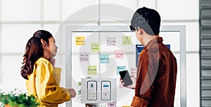 Ux developer and ui designer presenting  and testing mobile app interface design on whiteboard in meeting at modern office. photo