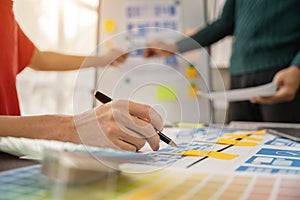 UX, UI developer and ui designer brainstorming about mobile app interface wireframe design with customer breif and color code at