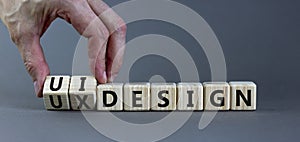 UX user experience design or UI user interface design symbol. Businessman turns cubes, changes words UX design to UI design.