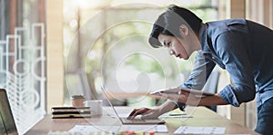 UX web developer working on his project about UX template while using laptop computer