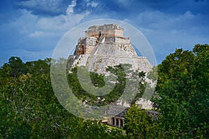 Uxmal ruin Mexico, Pyramid of the Magician in the green tropic forest with dark storm clouds. PirÃ¡mide Adivino in Uxmal, Maya photo