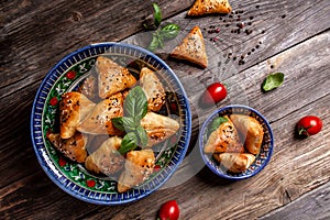 Uzbek and Central Asia cuisine concept. Samsa or Sambousak in national plate. Samsa or Sambousak an oriental meal to be stuffed
