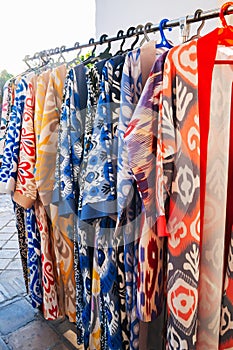 Uzbek dresses with a bright colored pattern at oriental bazaar in Uzbekistan in Tashkent