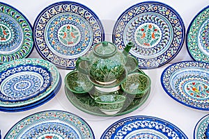 Uzbek handmade ceramic plates and teapot with hand-painted with a traditional Asian pattern in pottery workshop in