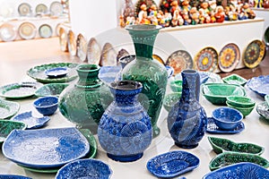 Uzbek handmade ceramic plates, vases and jug with hand-painted traditional Asian patterns in pottery workshop