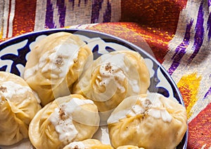 Uzbek national food manti on traditional fabric adras