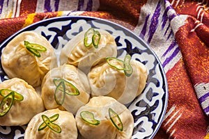 Uzbek national food manti on traditional fabric adras