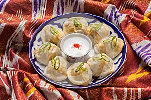 Uzbek national food Manti on traditional fabric adras