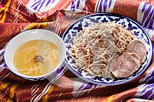 Uzbek national food norin on traditional fabric adras