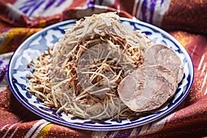 Uzbek national food norin on traditional fabric adras