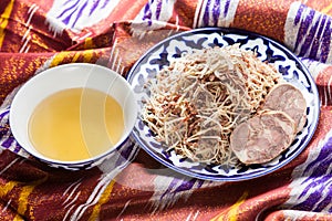 Uzbek national food norin on traditional fabric adras