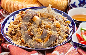 Uzbek national food pilaf on traditional fabric adras