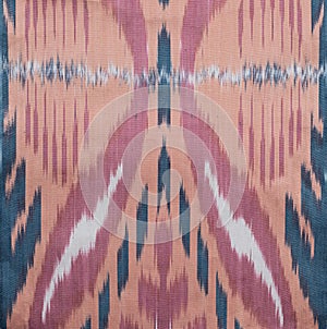 Uzbek pink and blue adras textile pattern texture. Close up background. Kurban Hayit, Ramadan, Navruz.