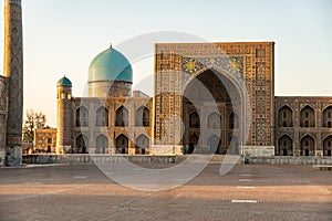 Uzbek religious architecture in facade of ancient Tilya-Kori madrasah with colorful ornament on brick walls