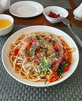 Uzbek traditional national food lagman, soup with noodles, vegetables and meat photo